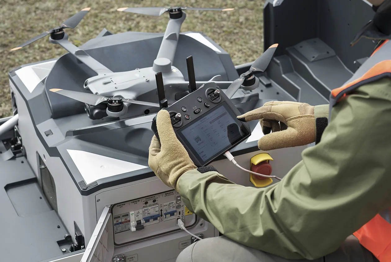 Técnico configurando el control remoto junto a la estación DJI Dock 2 y su dron